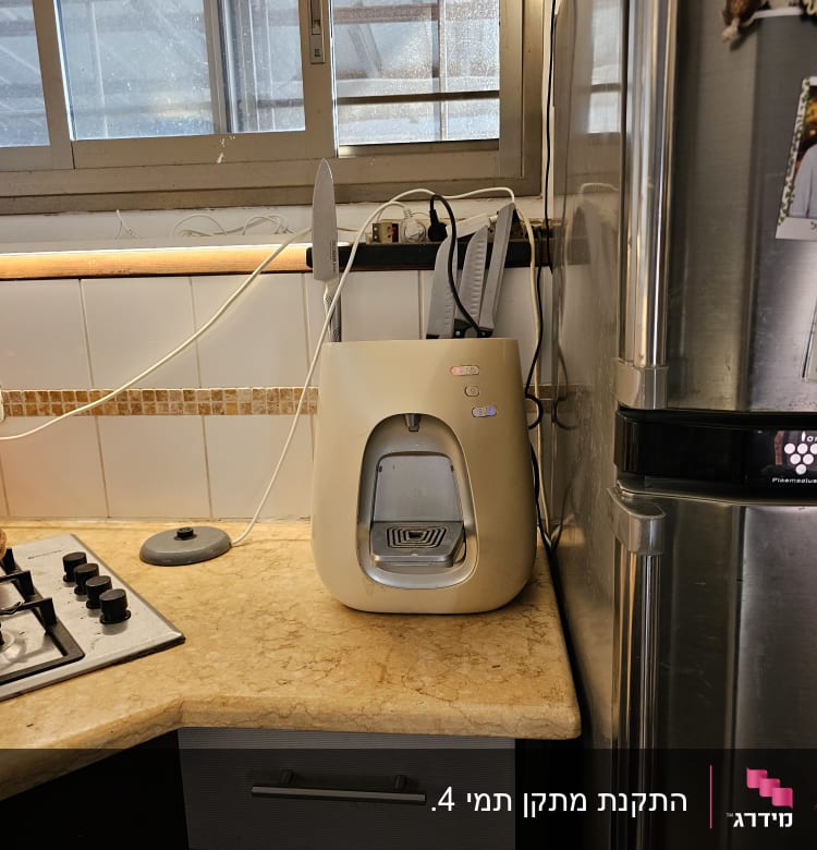 מכשיר מים על השיש במטבח ליד חלון